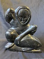 Front view of soapstone sculpture showing hunter and seal figures