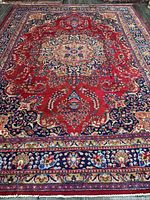 Full view of Mashhad rug showing central medallion, borders, overall design and fringe