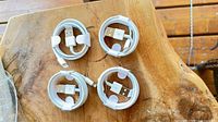 Four coiled white USB-A to Lightning cables on wood surface