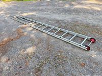 Full view of entire aluminum ladder laid on ground