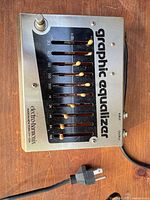 Top view showing all ten sliders, footswitch, branding and attached power cord