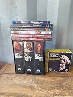 Stacked media showing Godfather VHS box, Beethoven CD box, and six disc cases