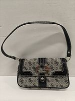 Front view of Guess monogram shoulder bag showing flap and turn-lock
