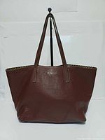 Front view of brown leather Peruzzi tote showing overall shape and dual handles