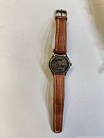 Front view of watch showing locomotive dial and brown strap