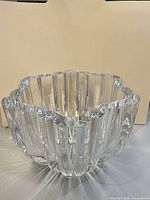 Angled side view showing fluted vertical panels and scalloped rim