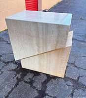 Pair of travertine side tables showing overall twisted block design
