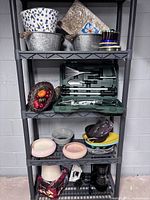 Full shelving unit showing garden tool set, galvanized tubs, ceramics, basket with faux fruit, coffee maker, iron and additional small items
