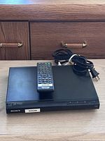 Front view of Sony DVD player with remote on top