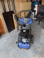 Front view of Simoniz 2600 PSI pressure washer showing engine, pump, wand, hose and nozzle panel