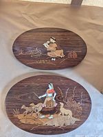 Front view of both oval plaques showing inlaid scenes