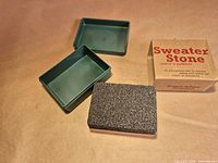 Stone, open plastic case halves, and cardboard box