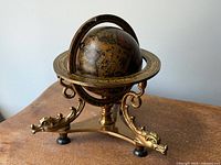 Full view of globe in ornate brass stand