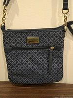 Front view of navy TH monogram crossbody bag with gold hardware