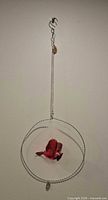 Full view of ornament showing hook, chain, circle frame, cardinal, and charm