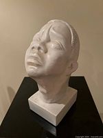 Front angle of white plaster head bust on plinth