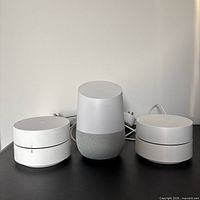 Front view showing Google Home speaker flanked by two Google Wifi routers