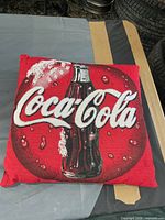 Front view of woven Coca-Cola pillow showing logo and bottle design