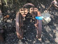 Front view showing pair of rusted metal spoked wheels with pedal footrests attached, marked Planet JR 12X23X13.5.