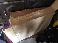 Photo of the opened cardboard box containing the pool cover packaging.