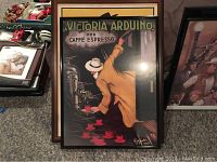 Framed Victoria Arduino Caffe Espresso advertising poster showing a man serving small red coffee cups, in a dark frame.