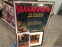 Framed Frankenstein movie poster titled 'The Man Who Made a Monster' along with smaller posters underneath.