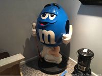 Full view of Blue M&M statue on wheeled base