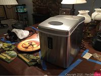 Edge Star portable ice maker unit on wooden table surrounded by various items.