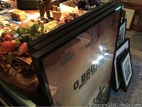 Side view of three stacked framed movie poster prints showing metal frames and acrylic covers