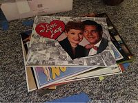 Stack of metal reproduction signs showing mostly the 'I Love Lucy' sign on top and other signs beneath.