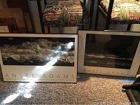 Two Ansel Adams framed prints side by side on carpet, larger and smaller.