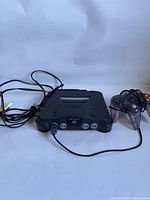 Front view of Nintendo 64 console with controller and cables visible