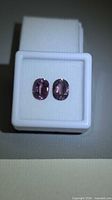 Pair of oval pink-purple spinels in presentation box