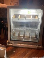 Front view of freezer with interior light on, shelves and dividers visible