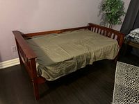 Full view of cherry wood daybed with mattress