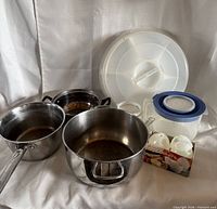 Group shot of stainless pots, plastic pitcher, divided tray, egg cookers