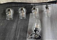 Vanity light with three glass shades and separate single ceiling light displayed together