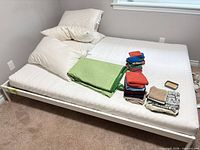 Overall view of assembled queen white metal platform bed frame supporting a mattress