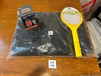All three items laid out: packaged netting, zapper racket, boxed lantern