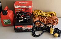 All items in lot: battery charger, box, cords, fuel can