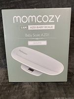 Factory-sealed retail box showing Momcozy AZ01 Baby Scale