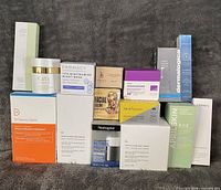Group shot of all boxed skincare items stacked on grey fabric