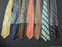 Seven packaged Chiarini ties laid out showing full length and patterns