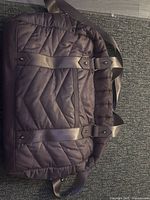 Front view of brown quilted nylon tote showing chevron quilting, straps and trim