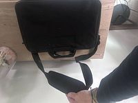 Front view of black HP laptop bag with shoulder strap