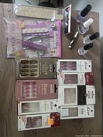 Overview showing boxed press-on nail sets, polishes, nail file kit and loose tools on table