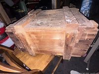 Angled view of crate showing construction, wood tone, paint splatters