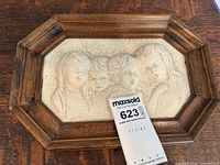 Full view of ceramic cherub plaque in octagonal wood frame with lot tag
