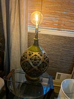 Full view of lit ceramic lamp on table