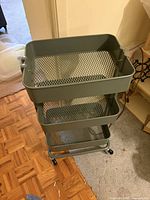 Top view of green 3-tier metal cart with wheels